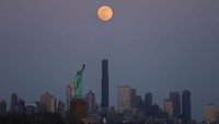 JERSEY CITY, NJ - MARCH 13: The full Worm Moon rises above the skyline of Brooklyn and the Statue of Liberty as the sun sets in New York City ahead of a total lunar eclipse on March 13, 2025, as seen from Jersey City, New Jersey. (Photo by Gary Hershorn/Getty Images)