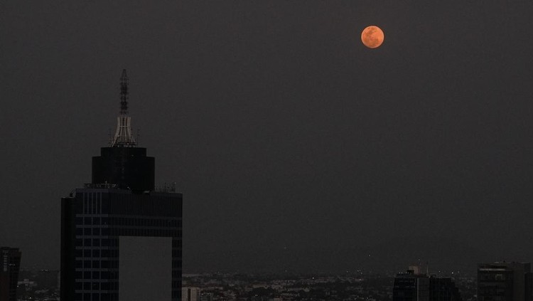 The moon shines over Mexico City during a total lunar eclipse, Thursday, March 13, 2025. (AP Photo/Marco Ugarte)