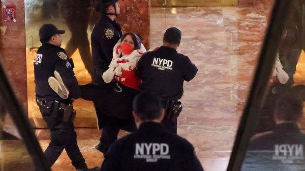 Petugas polisi menahan seorang pengunjuk rasa di dalam Trump Tower selama unjuk rasa menentang penahanan aktivis Palestina dan mahasiswa pascasarjana Universitas Columbia Mahmoud Khalil oleh ICE, di New York City, AS, 13 Maret 2025. (REUTERS/Jeenah Moon)