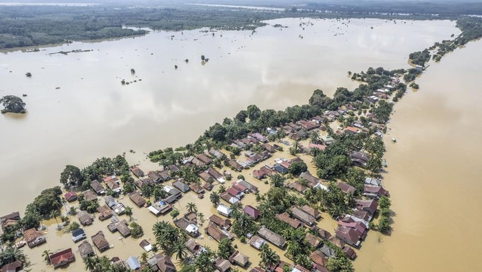 Foto udara warga menggunakan perahu melintasi kawasan permukiman tergenang banjir di Desa Pasar Terusan, Batanghari, Jambi, Kamis (13/3/2025). BPBD Kabupaten Batanghari mencatat ribuan rumah di tujuh kecamatan di kabupaten itu terendam banjir luapan Sungai Batanghari yang terus meninggi dalam beberapa hari terakhir. ANTARA FOTO/Wahdi Septiawan/Spt.