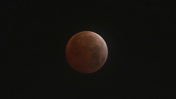 Warga menyaksikan fenomena gerhana bulan total di luar Planetarium di Buenos Aires, Argentina. Ini potretnya.