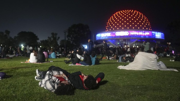 Warga Argentina Menikmati Gerhana Bulan Total di Luar Planetarium Warga menyaksikan fenomena gerhana bulan total di luar Planetarium di Buenos Aires, Argentina. Ini potretnya.
