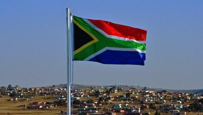 The South African flag flies near Qunu on June 26, 2013. Qunu is the city where former South African President Nelson Mandela grew up. Mandela remains in critical condition in hospital in Pretoria where he is being visited by family members. AFP PHOTO/Carl de Souza (Photo by Carl DE SOUZA / AFP)