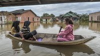 Warga menggunakan perahu untuk melintasi kawasan permukiman yang terendam banjir di Desa Sarang Burung, Jambi Luar Kota, Muaro Jambi, Jambi, Sabtu (15/3/2025).