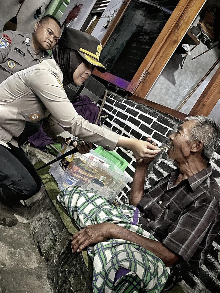 Kapolres Magelang Kota AKBP Anita Indah Setyaningrum saat menyuapi lansia, Slamet (70) warga Kota Magelang, Jumat (14/3/2025).
