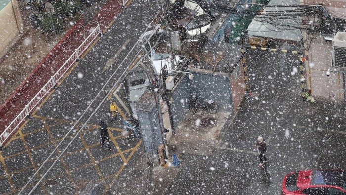 Warga berjalan saat hujan salju yang terjadi pada awal musim semi di Beijing, China pada Sabtu (15/03/2025). Observatorium Meteorologi Beijing mengumumkan bahwa kota Beijing mengalami penurunan suhu tajam di beberapa wilayah sehingga terjadi perubahan cuaca dari hujan menjadi salju dengan suhu berkisar 6 derajat pada siang hari hingga minus 2 derajat Celcius pada malam hari. ANTARA FOTO/Desca Lidya Natalia/foc.