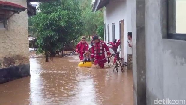 Tim SAR dari unsur Polisi mengevakuasi warga yang terjebak banjir di rumahnya, di RT01/RW06 Desa Cihanjuang, Kecamatan Cimanggung, Kabupaten Sumedang