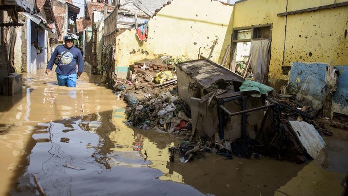 Warga berjalan melintasi banjir di Dayeuhkolot, Kabupaten Bandung, Jawa Barat, Minggu (16/3/2025). Banjir setinggi 30 sentimeter hingga 2 meter akibat luapan air Sungai Citarum saat intensitas curah hujan tinggi kembali merendam tiga kecamatan yakni Bojongsoang, Baleendah, dan Dayeuhkolot di Bandung Selatan. ANTARA FOTO/Novrian Arbi/tom.