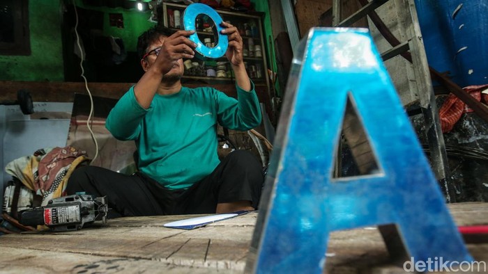 Melihat Kesibukan Perajin Reklame Huruf Timbul di Bulan Ramadan Pekerja menyelesaikan pengerjaan reklame huruf timbul di Pinggir Kali Ciliwung, Jatinegara, Jakarta, Minggu (16/3/2025).