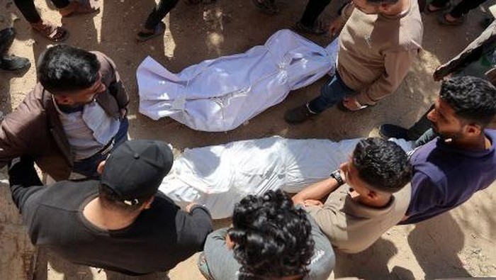 EDITORS NOTE: Graphic content / A man reacts as he bids farewell to one of the bodies of victims killed by Israeli bombardment in Beit Lahia in the northern Gaza Strip, outside the Indonesian hospital in Beit Lahia on March 15, 2025. Gazas civil defence agency said nine people including journalists were killed in the March 15 Israeli strikes in the north. Israel has carried out near-daily air strikes in Gaza since early March, often targeting what the military said were militants planting explosive devices. The truce in Israels war with Hamas, in effect since January 19, has largely held despite the attacks and with no agreement yet on extending the ceasefire. (Photo by Omar AL-QATTAA / AFP)