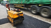 Pekerja memperbaiki jalan Pantura lingkar Payaman, Mejobo, Kudus, Jawa Tengah, Sabtu (15/3/2025).