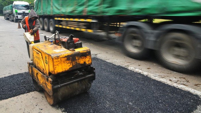 Pekerja memperbaiki jalan Pantura lingkar Payaman, Mejobo, Kudus, Jawa Tengah, Sabtu (15/3/2025). Kementerian Pekerjaan Umum (PU) mulai memperbaiki jalan nasional Pantura jalur Semarang-Surabaya tersebut sepanjang 10 kilometer sebagai kesiapan jalur mudik Lebaran 2025 guna memberikan kenyamanan dan keselamatan bagi pengendara.