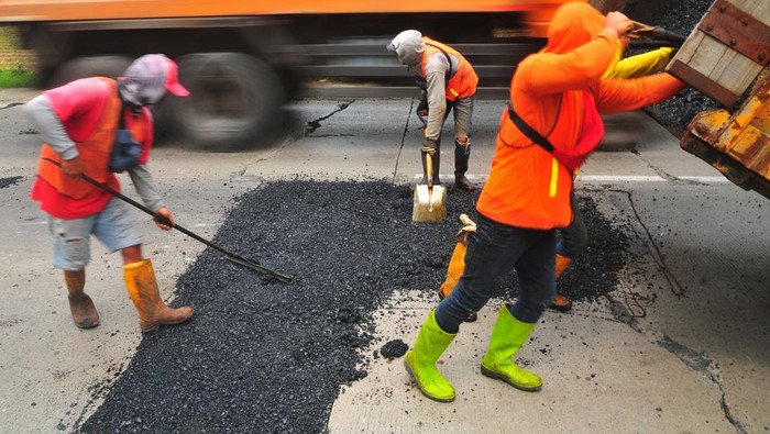 Pekerja memperbaiki jalan Pantura lingkar Payaman, Mejobo, Kudus, Jawa Tengah, Sabtu (15/3/2025). Kementerian Pekerjaan Umum (PU) mulai memperbaiki jalan nasional Pantura jalur Semarang-Surabaya tersebut sepanjang 10 kilometer sebagai kesiapan jalur mudik Lebaran 2025 guna memberikan kenyamanan dan keselamatan bagi pengendara.