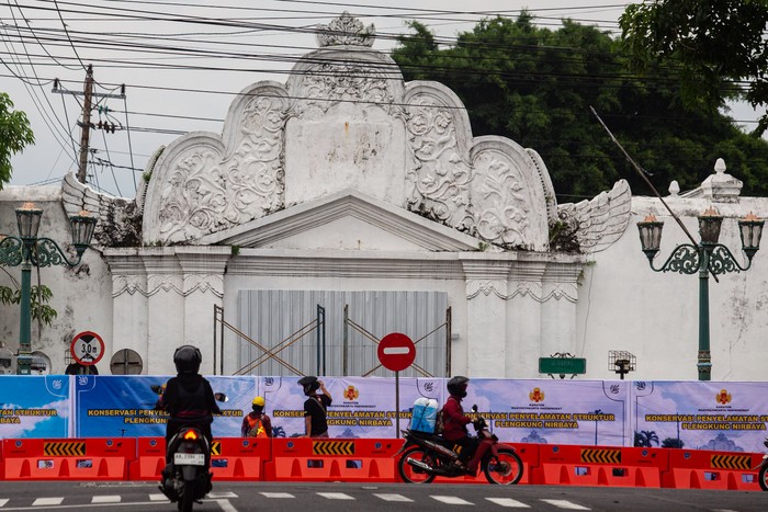 Pekerja beristirahat seusai memasang banner penutup bangunan cagar budaya Plengkung Gading atau disebut juga Plengkung Nirbaya di  Yogyakarta, Sabtu (15//3/2025). Pemda D.I Yogyakarta menutup Plengkung Gading secara total sebagai upaya konservasi penyelamatan struktur Plengkung Gading menyusul beberapa bagian bangunan itu mengalami kerusakan sehingga berpotensi membahayakan pengendara. ANTARA FOTO/Andreas Fitri Atmoko/foc.