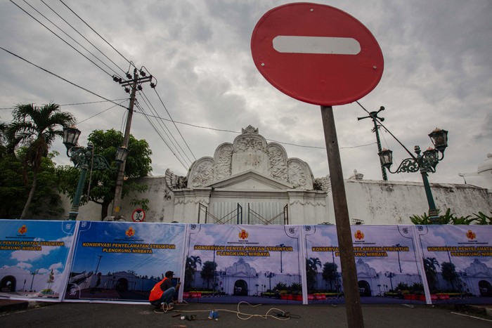 Pekerja beristirahat seusai memasang banner penutup bangunan cagar budaya Plengkung Gading atau disebut juga Plengkung Nirbaya di  Yogyakarta, Sabtu (15//3/2025). Pemda D.I Yogyakarta menutup Plengkung Gading secara total sebagai upaya konservasi penyelamatan struktur Plengkung Gading menyusul beberapa bagian bangunan itu mengalami kerusakan sehingga berpotensi membahayakan pengendara. ANTARA FOTO/Andreas Fitri Atmoko/foc.