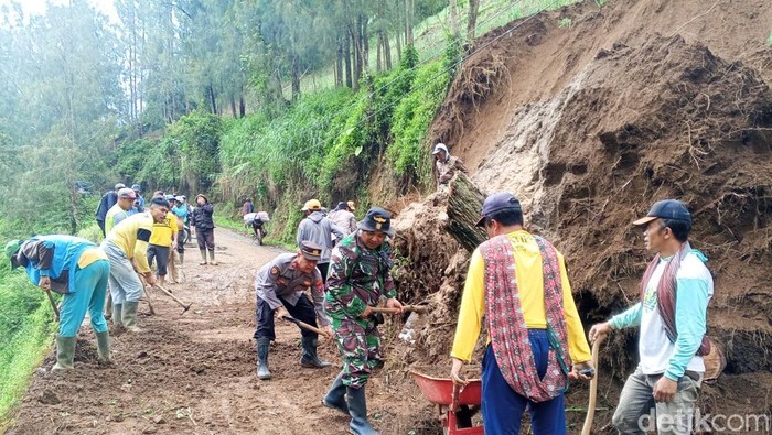 Polisi, TNI, dan BPBD bersihkan material longsot di Probolinggo.