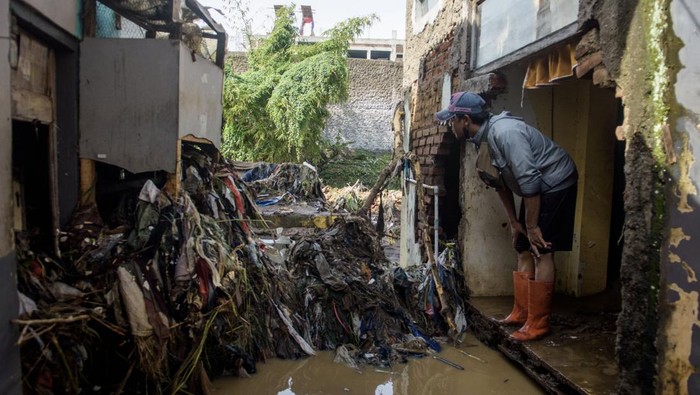 Puluhan Rumah Rusak Akibat Tanggul Sungai Cigede Jebol Warga menggunakan gawai di depan rumah yang rusak terdampak banjir akibat tanggul Sungai Cigede jebol di Desa Citeureup, Kabupaten Bandung, Jawa Barat, Minggu (16/3/2025). Puluhan rumah mengalami kerusakan serta ratusan kepala keluarga terdampak banjir akibat tanggul Sungai Cigede sepanjang 30 meter jebol saat hujan dengan intensitas tinggi pada Sabtu (15/5) malam. ANTARA FOTO/Novrian Arbi/tom.