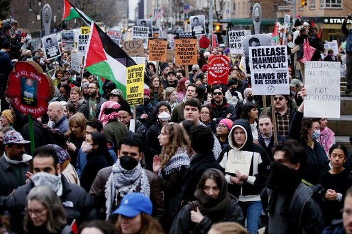 Pro-Palestinian activists hold signs and wave flags as they participate in a 
