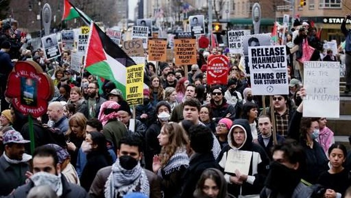 Pro-Palestinian activists hold signs and wave flags as they participate in a 