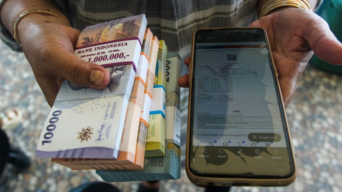 Warga menunjukkan uang dan bukti pendaftaraan lewat aplikasi setelah menukarkan pecahan uang baru pada mobil kas keliling Bank Indonesia di Masjid Nurul Hidayah Kelapa Lima, Kota Kupang, Nusa Tenggara Timur, Jumat (7/3/2025). Kantor Perwakilan Bank Indonesia (BI) Provinsi Nusa Tenggara Timur kembali membuka layanan penukaran uang baru untuk mempermudah transaksi serta memenuhi kebutuhan masyarakat akan uang pecahan baru selama Ramadhan dan Idul Fitri. ANTARA FOTO/Mega Tokan