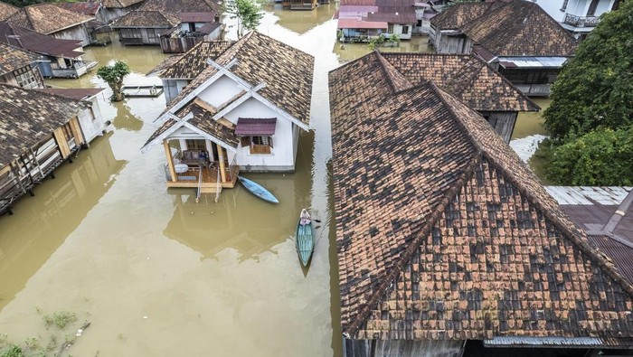 Foto udara warga menggunakan perahu untuk melintasi kawasan permukiman yang terendam banjir di Pelayangan, Jambi, Senin (17/3/2025).  Pemerintah Kota Jambi mencatat banjir luapan Sungai Batanghari yang terjadi sepekan terakhir meluas hingga ke tujuh kecamatan atau berdampak kepada 4.621 jiwa. ANTARA FOTO/Wahdi Septiawan/rwa.