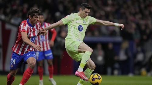 Barcelonas Robert Lewandowski, right, controls the ball challenged by Atletico Madrids Robin Le Normand during a La Liga soccer match between Atletico Madrid and FC Barcelona at the Metropolitano stadium in Madrid, Sunday, March 16, 2025. (AP Photo/Bernat Armangue)