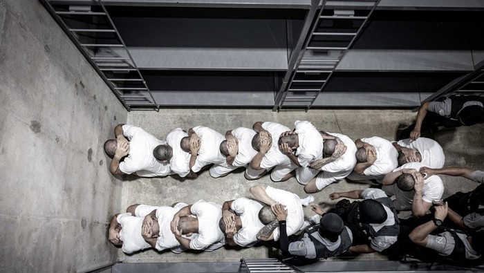 Meski Ditolak Pengadilan, Trump Kirim 238 Gangster ke Penjara El Salvador Salvadoran police officers escort alleged members of the Venezuelan gang Tren de Aragua recently deported by the U.S. government to be imprisoned in the Terrorism Confinement Center (CECOT) prison, as part of an agreement with the Salvadoran government, at the El Salvador International Airport in San Luis Talpa, El Salvador, in this handout image obtained March 16, 2025. Secretaria de Prensa de la Presidencia/Handout via REUTERS ATTENTION EDITORS - THIS IMAGE HAS BEEN SUPPLIED BY A THIRD PARTY. NO RESALES. NO ARCHIVES TPX IMAGES OF THE DAY