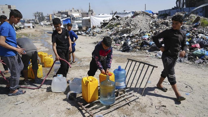 Warga Gaza Masih Krisis Air Bersih Palestinians fill cans with water in Jabaliya, northern Gaza Strip, Sunday, March 16, 2025. (AP Photo/Abdel Kareem Hana)