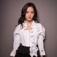 Pelantun ‘earthquake’ itu memadukan korset putih dengan detail ritsleting dengan kemeja beraksen ruffle, dan rok mini tulle berlapis renda. Untuk menyempurnakan penampilannya, Jisoo BLACKPINK memakai sepatu boots dan hand bag Lady Dior. Foto: Getty Images