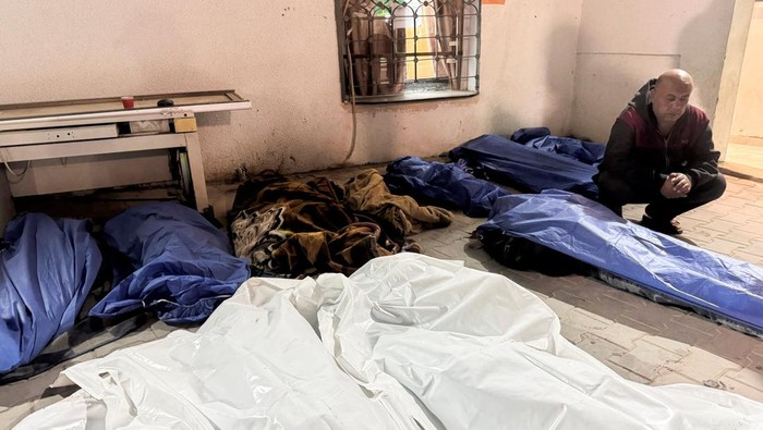 SENSITIVE MATERIAL. THIS IMAGE MAY OFFEND OR DISTURB    Mourners gather near the bodies of Palestinians killed in Israeli strikes, at a hospital in Gaza City March 18, 2025. REUTERS/Stringer