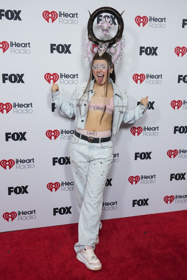 Untuk busana, Jojo Siwa mengenakan setelan denim berkilauan yang dipadukan dengan bra dan celana dalam pink dari Versace. Foto: Jordan Strauss/Invision/AP/Jordan Strauss