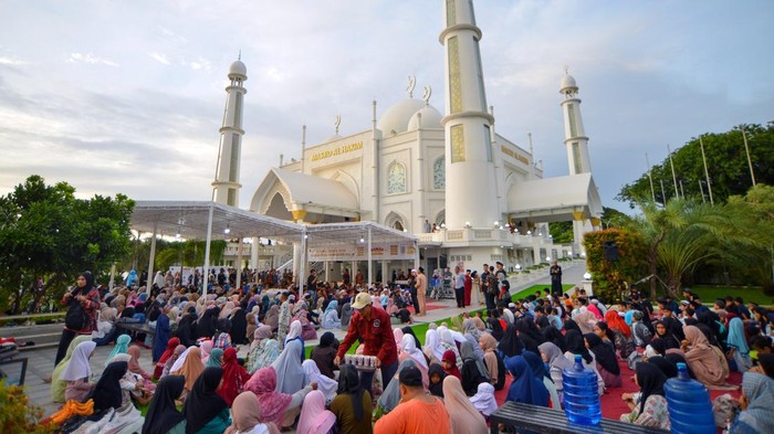 Pengunjung menunggu waktu berbuka puasa dan takjil gratis di pelataran Masjid Al-Hakim, Padang, Sumatera Barat, Jumat (14/3/2025). Masjid yang memiliki gaya arsitektur Taj Mahal dan dibangun pada awal tahun 2017 di tepi pantai itu menjadi tujuan wisata religi di kota Padang yang sering dikunjungi wisatawan. ANTARA FOTO/Iggoy el Fitra/tom.