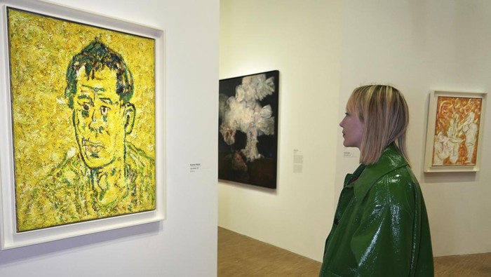 A man photographs the 1965 painting 