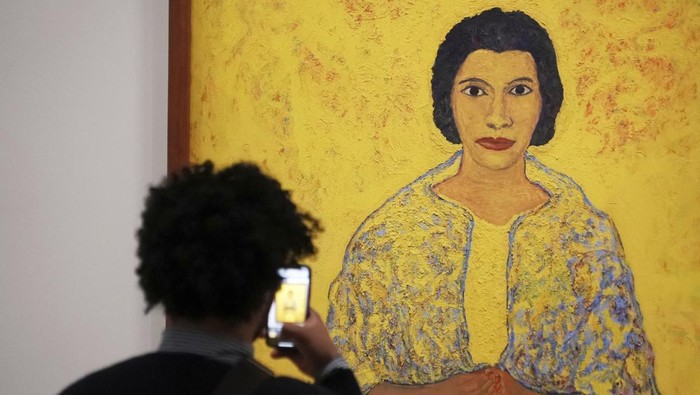 A man photographs the 1965 painting 