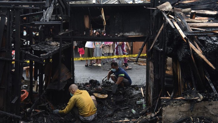 Pedagang dibantu warga mengumpulkan barang dagangan yang masih bisa dimanfaatkan usai kebakaran melanda Pasar Poncol di Kawasan Bungur, Jakarta Pusat, Selasa (18/3/2025). Kebakaran yang menghanguskan sekitar 35 unit kios di pasar tersebut diduga terjadi akibat korsleting listrik. ANTARA FOTO/Indrianto Eko Suwarso/Spt.