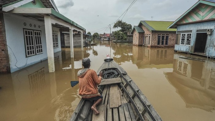 Foto udara warga menggunakan perahu melintasi jalan kawasan permukiman yang terendam banjir luapan Sungai Batanghari di Dusun Mudo, Taman Rajo, Muaro Jambi, Jambi, Selasa (18/3/2025). Pemkab Muaro Jambi mencatat, sebanyak tujuh  Pemkab Muaro Jambi mencatat sebanyak tujuh desa di Kecamatan Taman Rajo   terisolasi akibat banjir setinggi 1 meter lebih yang menggenangi akses jalan dan berdampak kepada ratusan KK. ANTARA FOTO/Wahdi Septiawan/nz.