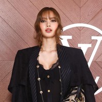 Tahun ini, Lisa BLACKPINK mengenakan blazer dan jumpsuit berwarna hitam yang mengekspos bagian dadanya. Penampilannya disempurnakan dengan koleksi ankle boots dan LV Biker PM bag. Foto: dok. Getty Images