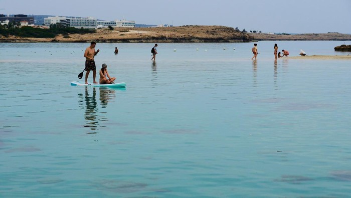 People enjoy the hot weather in the sea in Ayia Napa resort, in the easter Mediterranean island of Cyprus, Monday, March 17, 2025. (AP Photo/Petros Karadjias)