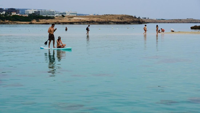 Pesona Pulau di Mediterania yang Cantik People enjoy the hot weather in the sea in Ayia Napa resort, in the easter Mediterranean island of Cyprus, Monday, March 17, 2025. (AP Photo/Petros Karadjias)