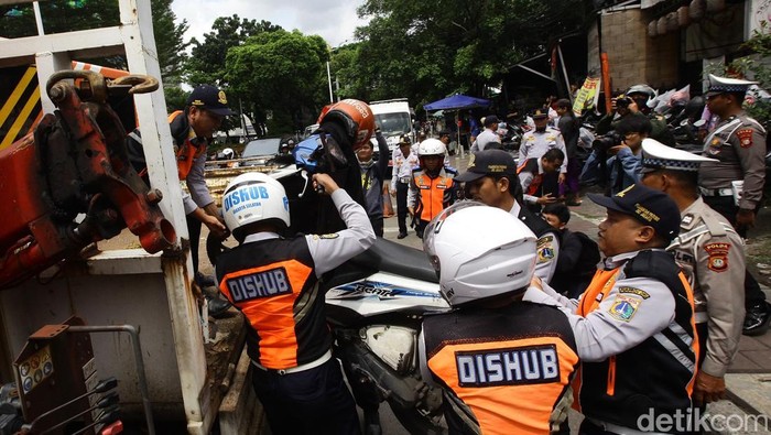 Razia Parkir Liar di Jakarta, Motor Diangkut Petugas Petugas Sudin Perhubungan Jakarta Selatan mengangkut sepeda motor yang parkir di bahu jalan ke atas truk di kawasan Gandaria City, Jakarta, Selasa (18/3/2025). Dalam rangka Operasi Lintas Jaya Suku Dinas Perhubungan Kota Administrasi Jakarta Selatan menertibkan 12 kendaraan bermotor roda dua yang parkir liar di bahu jalan sebagai upaya menciptakan kenyamanan dan kelancaran lalu lintas.