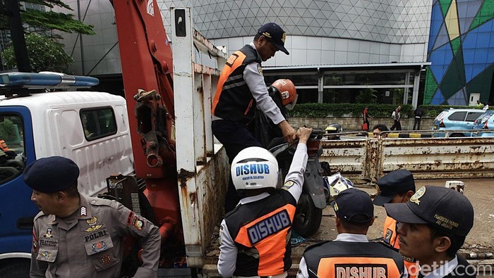 Razia Parkir Liar di Jakarta, Motor Diangkut Petugas Petugas Sudin Perhubungan Jakarta Selatan mengangkut sepeda motor yang parkir di bahu jalan ke atas truk di kawasan Gandaria City, Jakarta, Selasa (18/3/2025). Dalam rangka Operasi Lintas Jaya Suku Dinas Perhubungan Kota Administrasi Jakarta Selatan menertibkan 12 kendaraan bermotor roda dua yang parkir liar di bahu jalan sebagai upaya menciptakan kenyamanan dan kelancaran lalu lintas.
