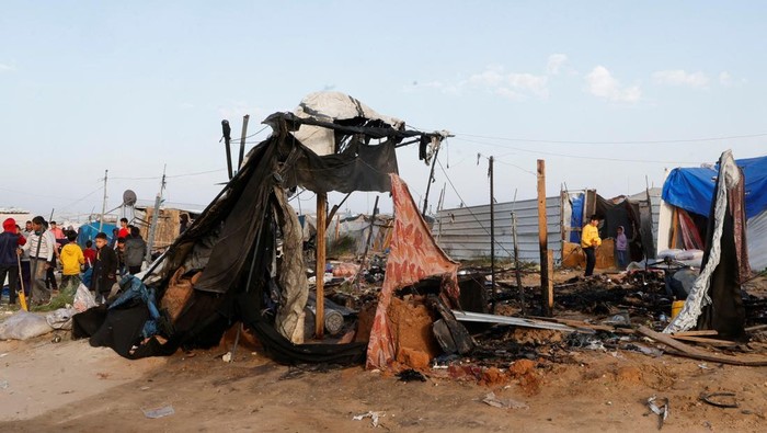 Palestinians inspect the site of an Israeli strike on a tent camp housing displaced people, in Al-Mawasi area, in Khan Younis in the southern Gaza Strip March 18, 2025. REUTERS/Hatem Khaled