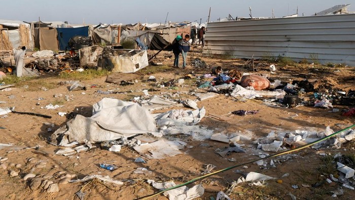 Palestinians inspect the site of an Israeli strike on a tent camp housing displaced people, in Al-Mawasi area, in Khan Younis in the southern Gaza Strip March 18, 2025. REUTERS/Hatem Khaled