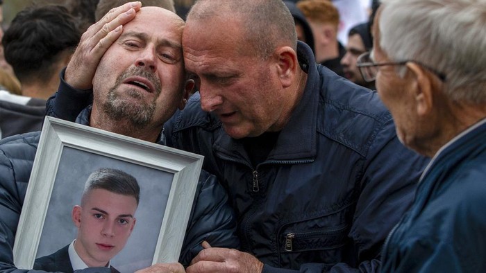 Dragi Stojanov, left, cries holding a photograph of his son Tomche Stojanov, one of the victims of a massive nightclub fire, during a vigil joined by hundreds in the town of Kocani, North Macedonia, Monday, March 17, 2025. (AP Photo/Visar Kryeziu)