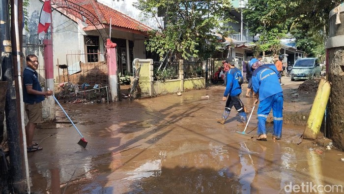 Warga dan petugas dinas SDA membersihkan lumpur bekas banjir di Cawang, Kramat Jati, Jakarta Timur. (Fawdi/detikcom)