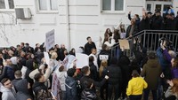 Orang-orang berunjuk rasa di dekat rumah pemilik klub malam yang menjadi lokasi kebakaran besar, setelah acara penghormatan bagi para korban di kota Kocani, Makedonia Utara, Senin (17/3/2025). (AP Photo/Boris Grdanoski)