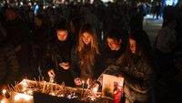 Para pelayat menyalakan lilin, berpelukan dan menangis, serta menulis pesan belasungkawa di alun-alun. (AP Photo/Armin Durgut)