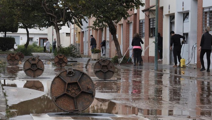 Banjir Melanda Spanyol, 2 Orang Hilang dan Ratusan Orang Dievakuasi Residents clear mud from the streets after heavy rains in Campanillas, Malaga, Spain, Tuesday, March 18, 2025. (AP Photo/Gregorio Marrero)