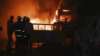 Polisi mengawasi kendaraan yang dibakar selama bentrokan komunal yang dipicu oleh protes yang menuntut pemindahan makam penguasa Muslim Mughal abad ke-17 Aurangzeb di Nagpur, India, Senin (17/3/2025).