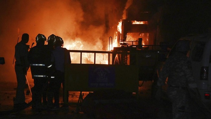 Residents stand next to burnt vehicles a day after communal clashes sparked by protests demanding removal of the tomb of 17th-century Muslim Mughal ruler Aurangzeb in Nagpur, India, Tuesday, March 18, 2025. (AP Photo)